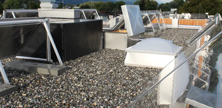 Flachdach mit Kieselsteinabdeckung und verschiedenen Lüftungs- und Dachaufbauten